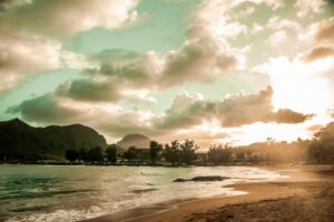 waves splashing by the seashore under a cloudy sky during golden hour / Photo by Dustin Belt on Unsp