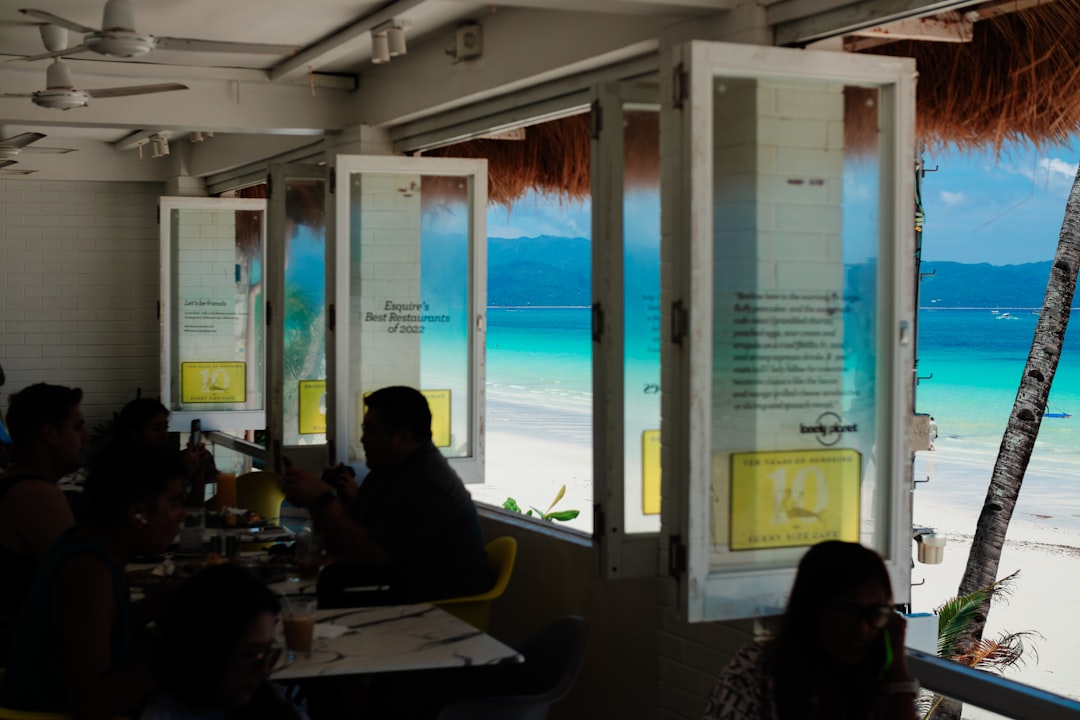 A group of people sitting at a table in front of a window
