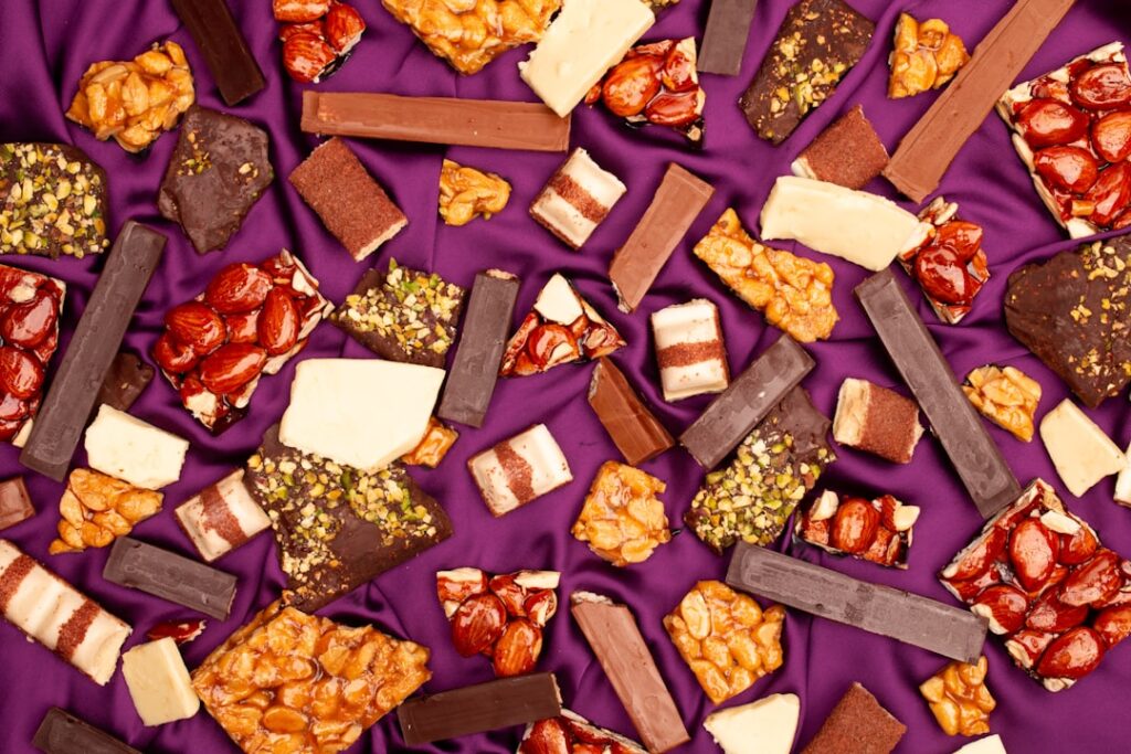 Assortment of chocolate bars and candies on purple fabric