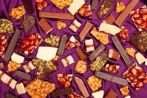 Assortment of chocolate bars and candies on purple fabric