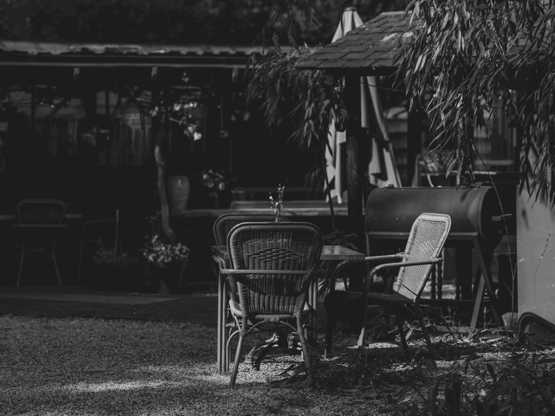Black and white outdoor patio with table, chairs, and grill