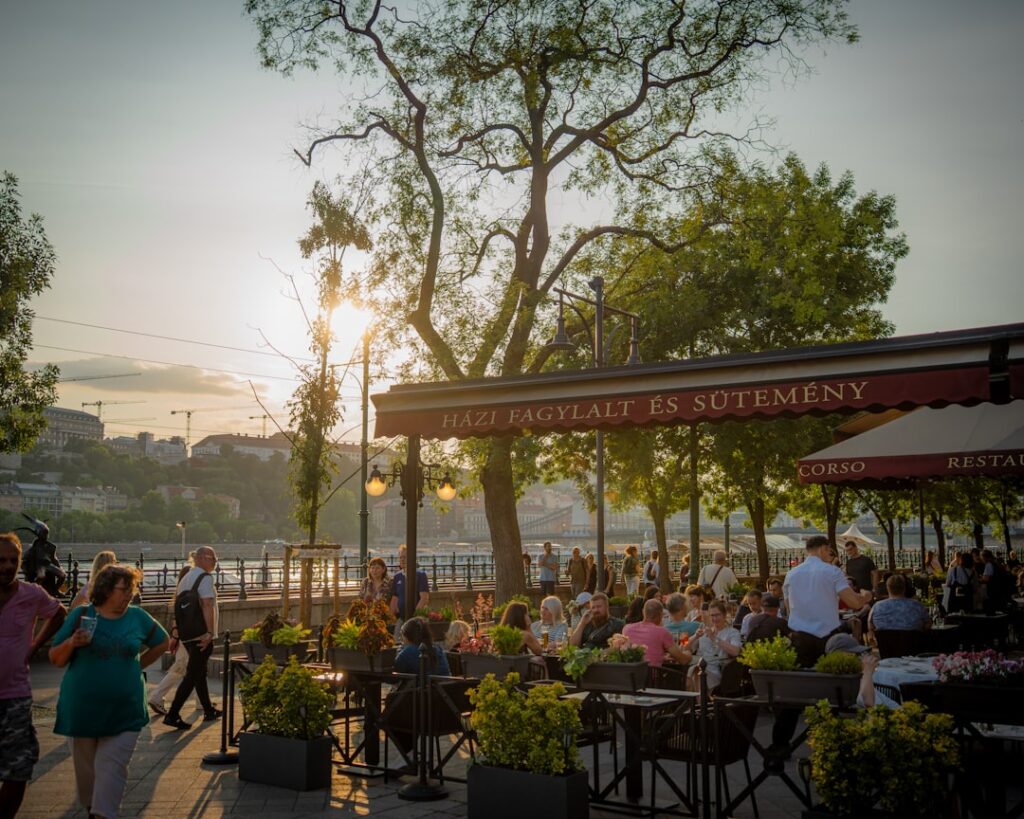 People gather at an outdoor restaurant by the river