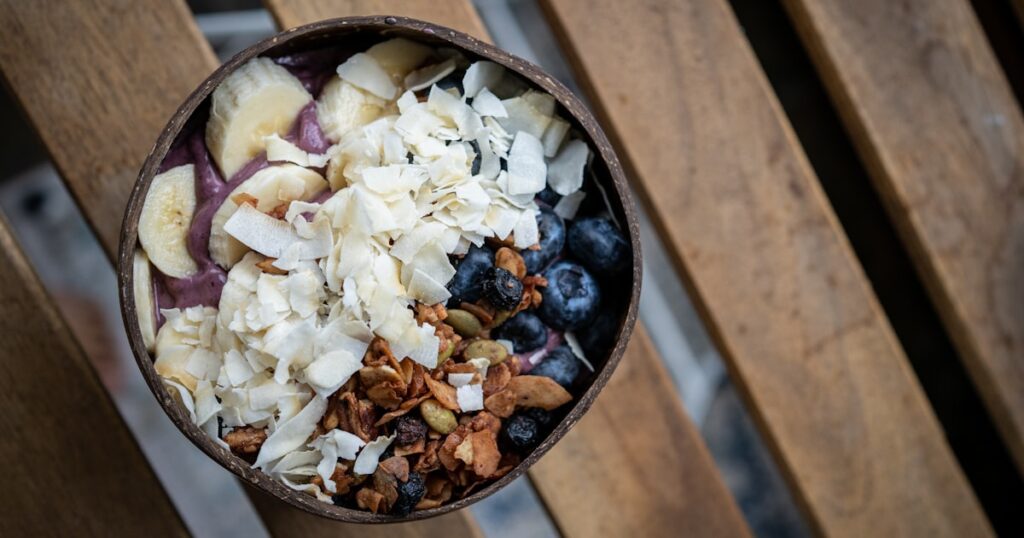 a bowl filled with granola, blueberries, and nuts