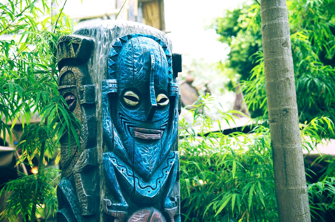 blue and black wooden human face carved statue