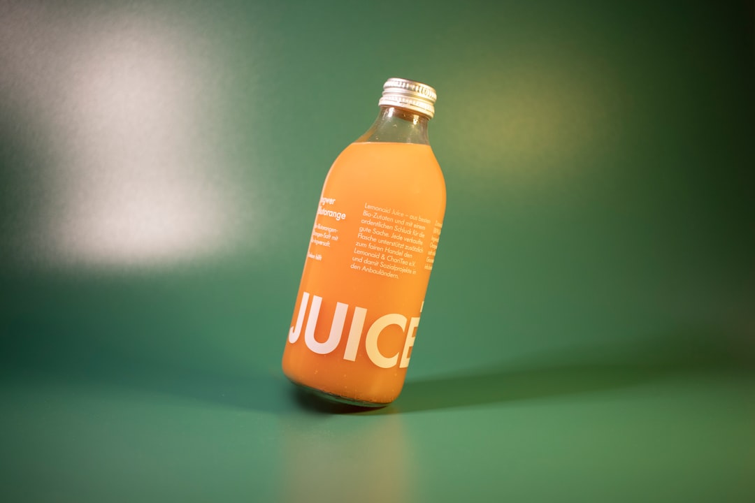 a bottle of juice sitting on a green surface