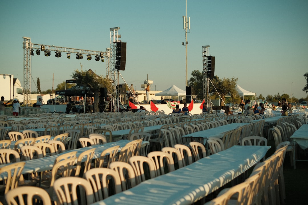 Rows of empty tables and chairs at an outdoor event