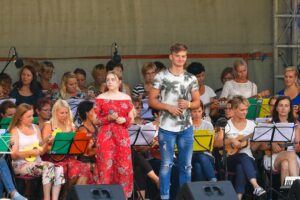 Young singers perform on stage with orchestra