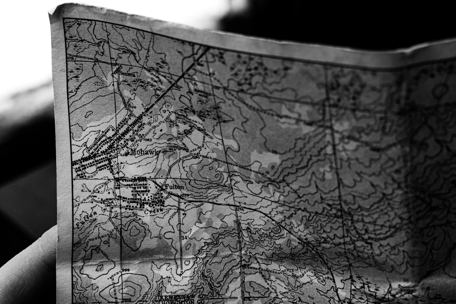 手に持たれたモノクロの紙の地図