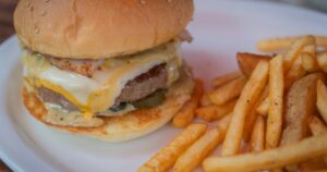 白い皿に盛られたチーズバーガーとフレンチフライ
